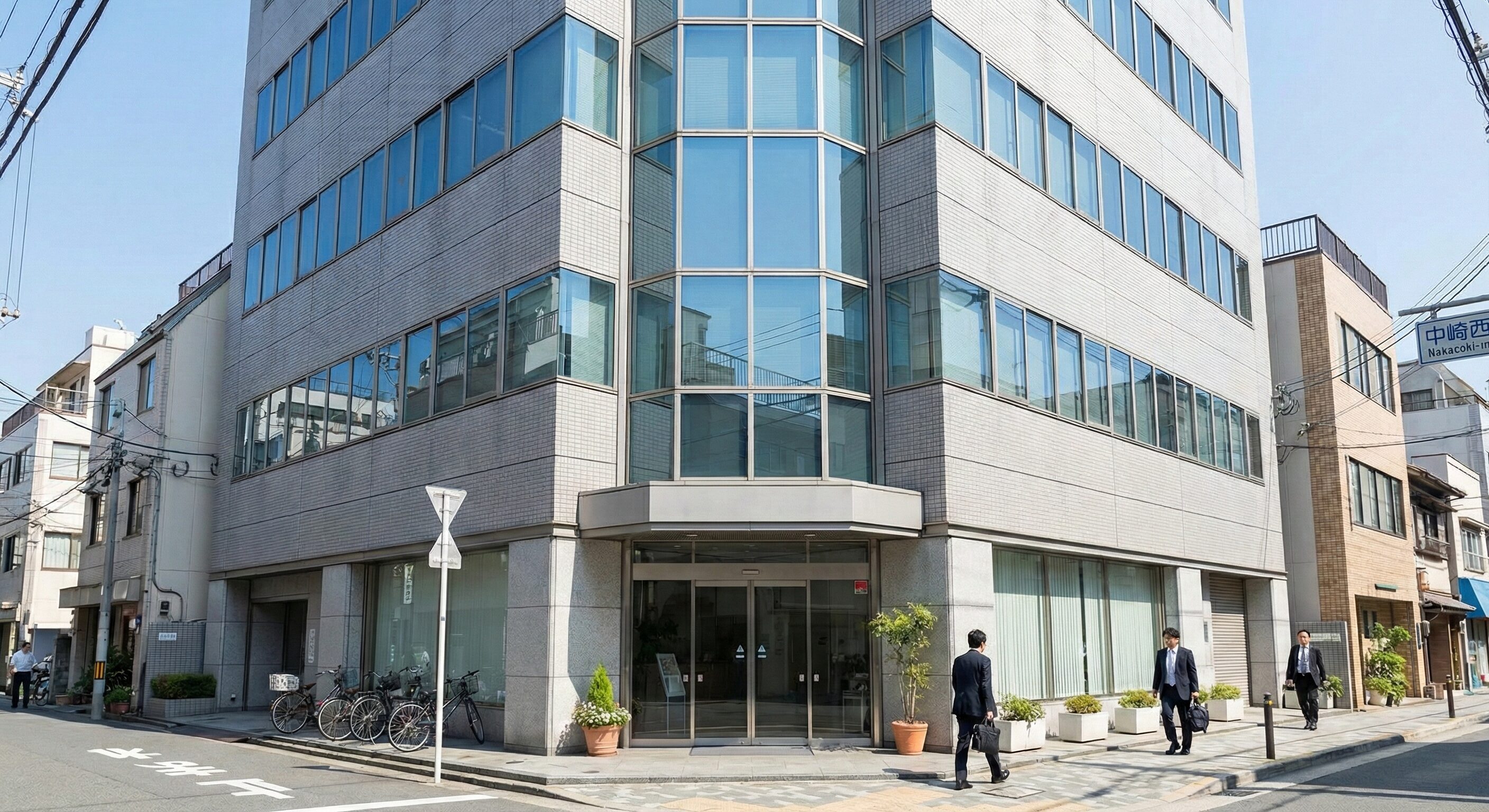 大阪市北区中崎西エリアのビジネスビル外観写真。晴天の日中に撮影された、清潔感のある中規模オフィスビルの正面写真。